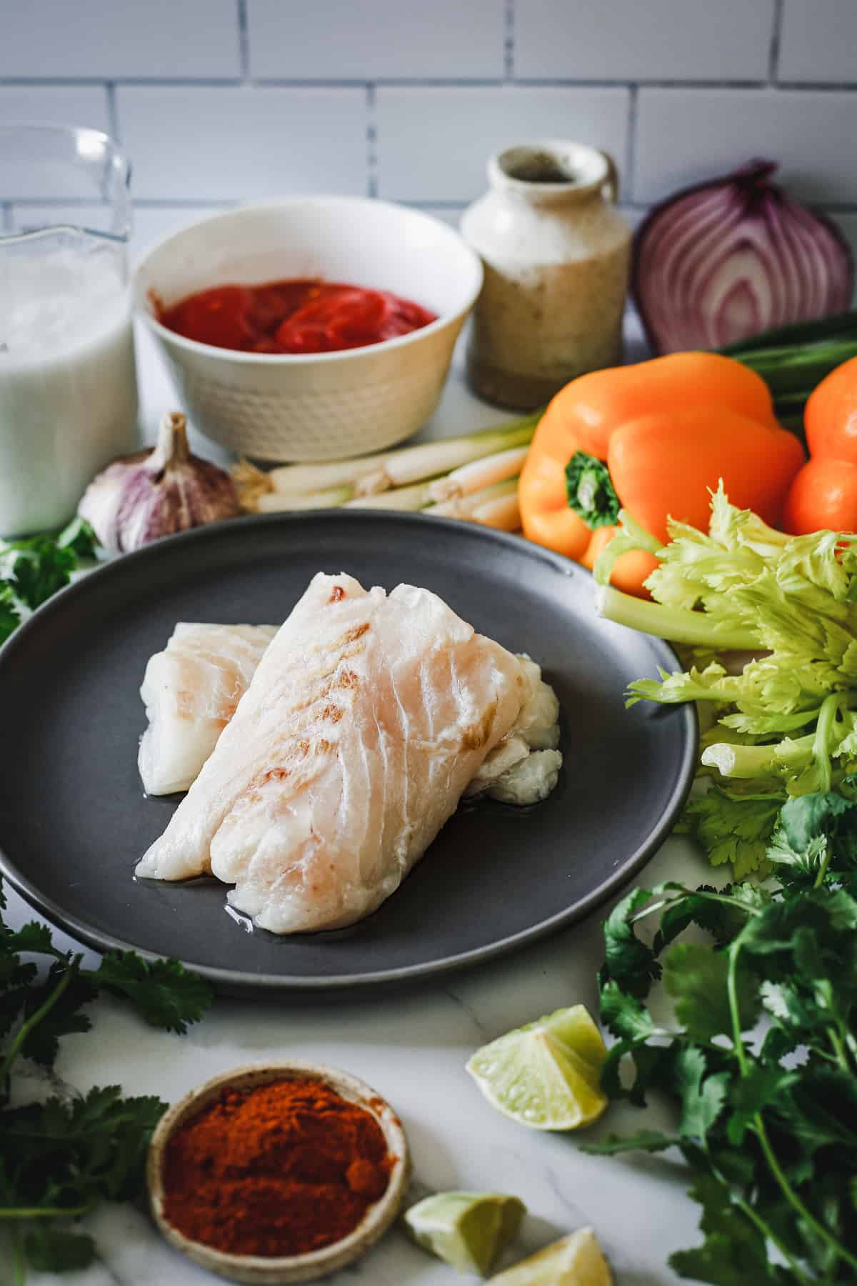 A plate of fish and vegetables on a table.