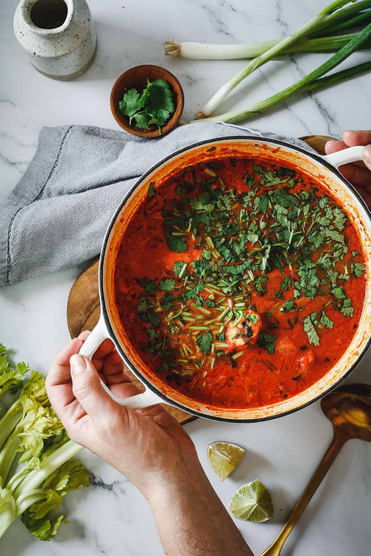 A person holding a pot of moqueca.