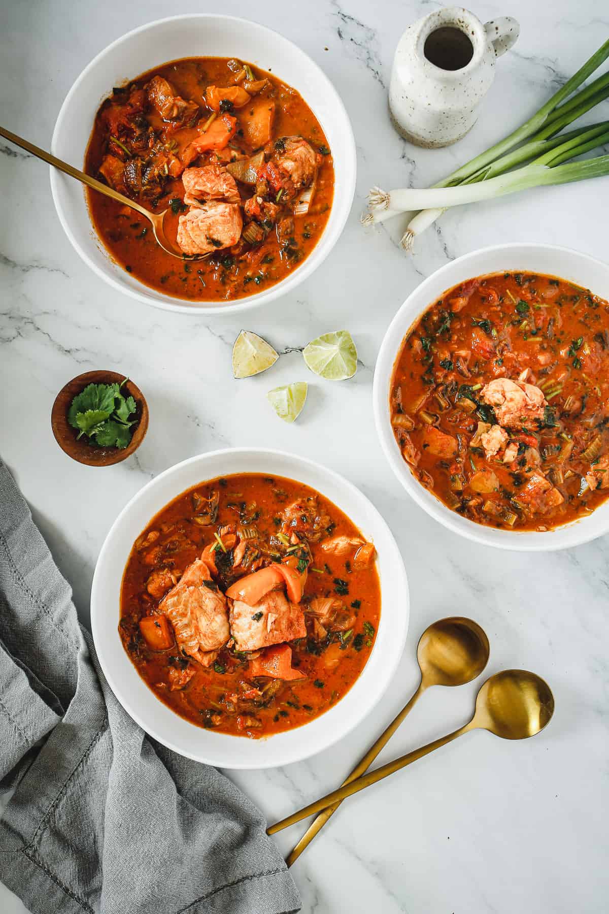 Three bowls of soup on a marble table.