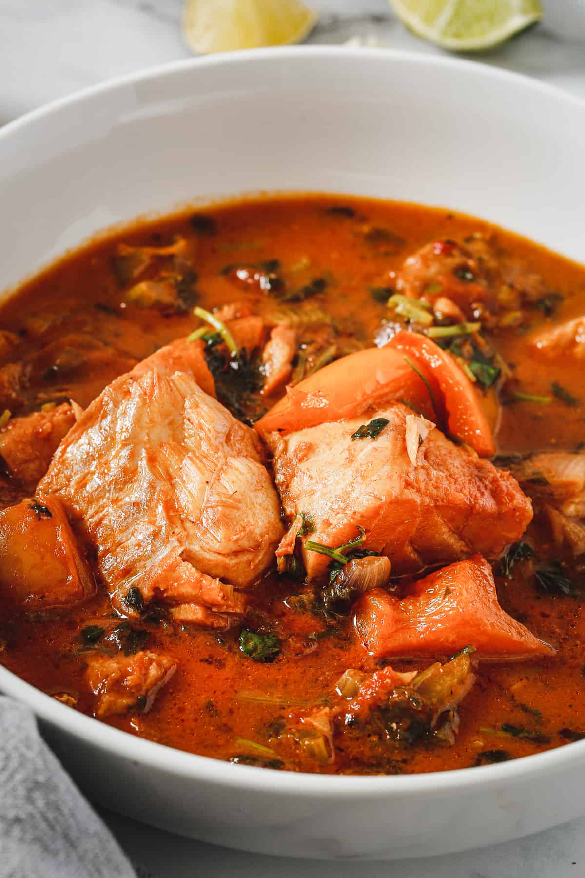 A bowl of stew with fish in it.