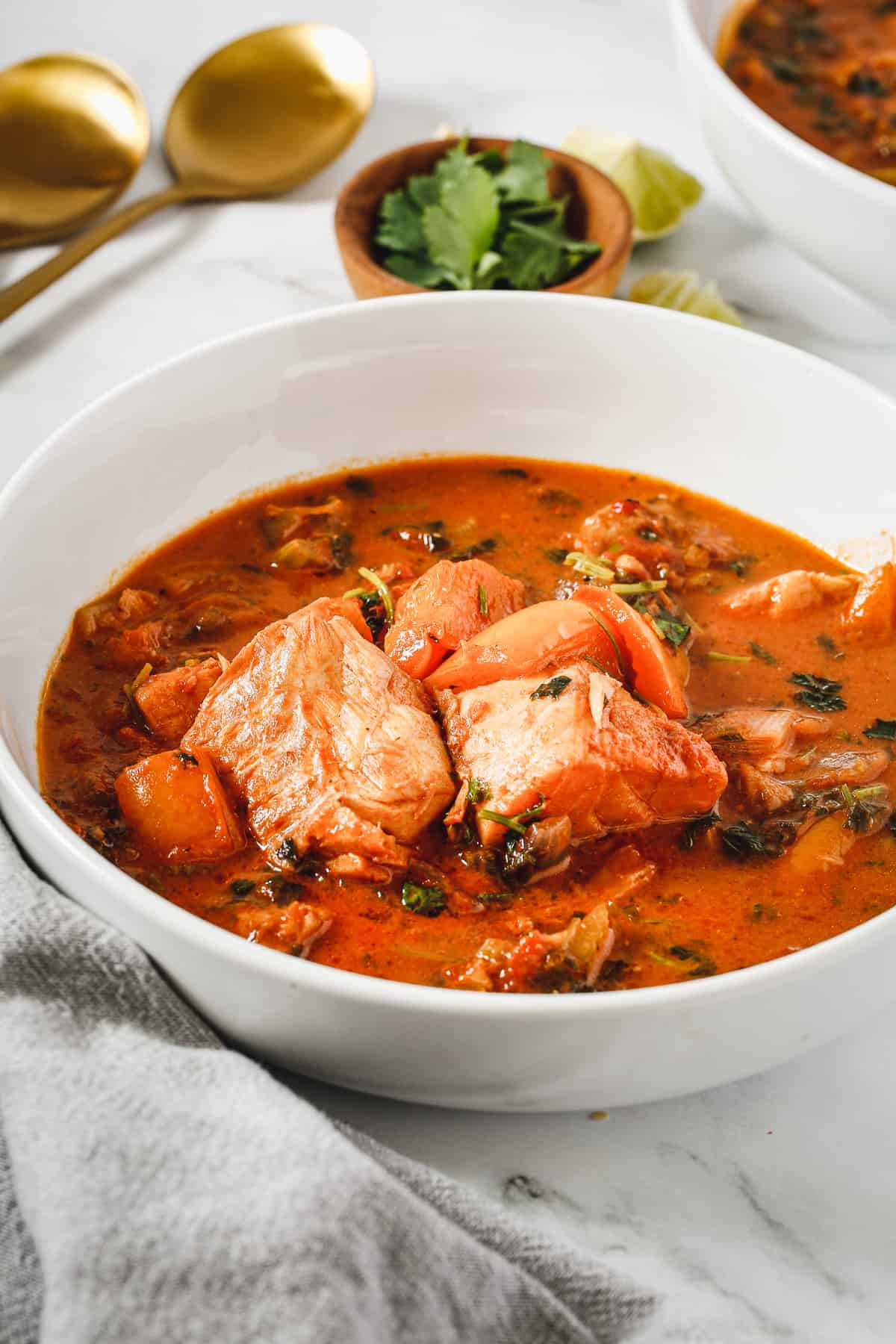 A bowl of brazilian moqueca with a spoon in it.