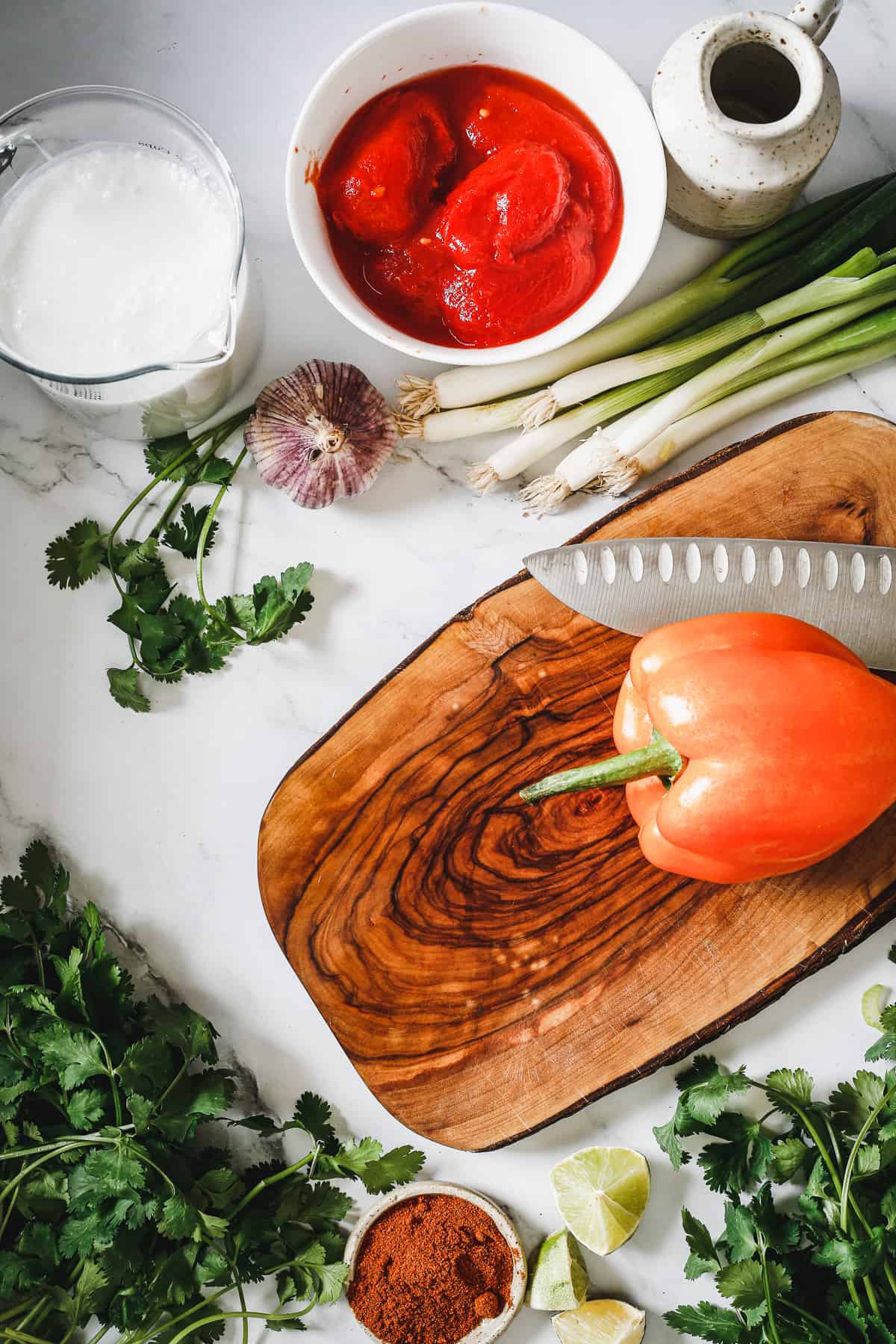 Ingredients for a fish stew recipe on a cutting board.