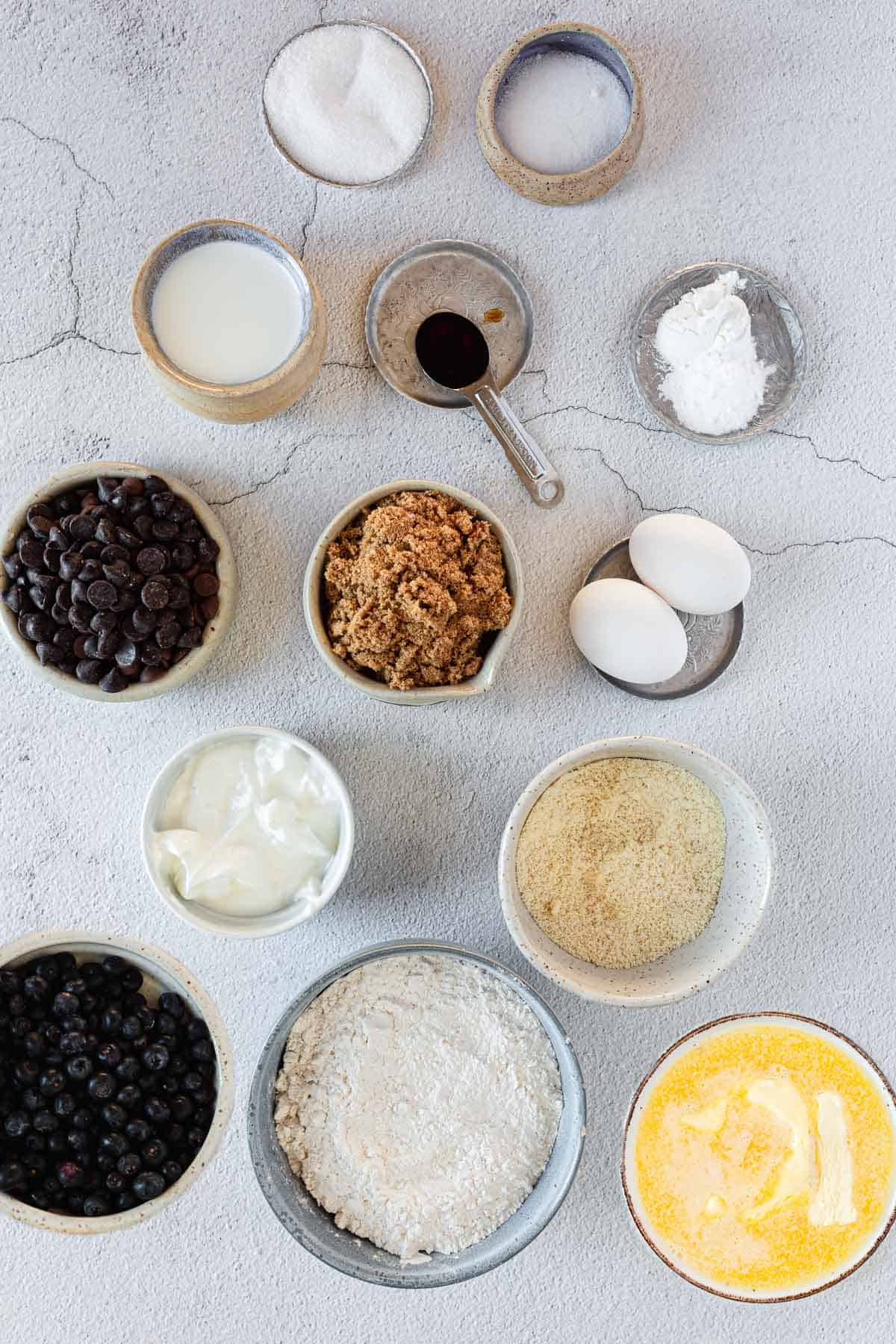 Various bowls of gluten free ingredients for a chocolate chip cake.