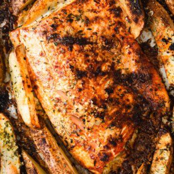 Salmon on baking sheet with potatoes.