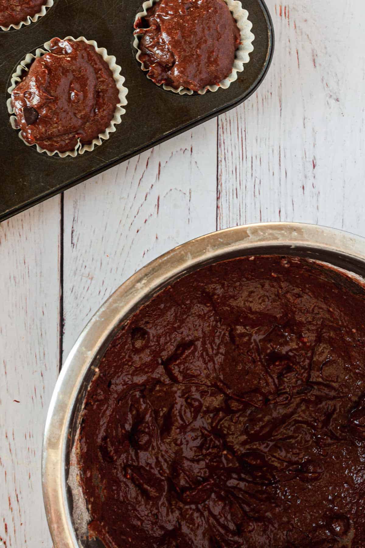 Chocolate muffins in a pan on a wooden table.