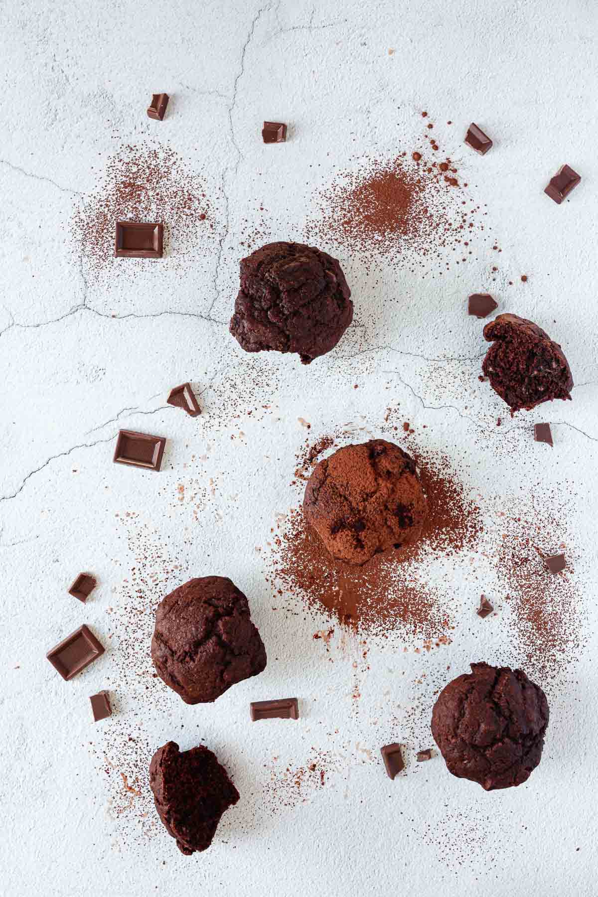 A group of chocolate banana muffins on a white surface.