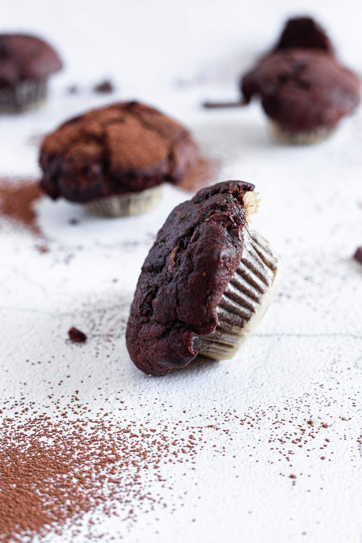 A group of chocolate muffins on a white surface.