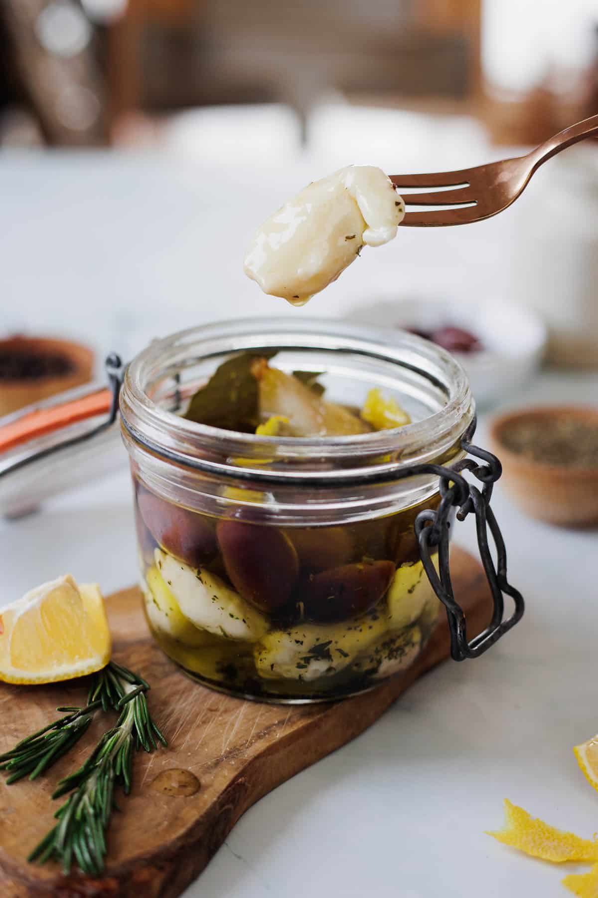 cheese curds in a jar on a wooden cutting board.