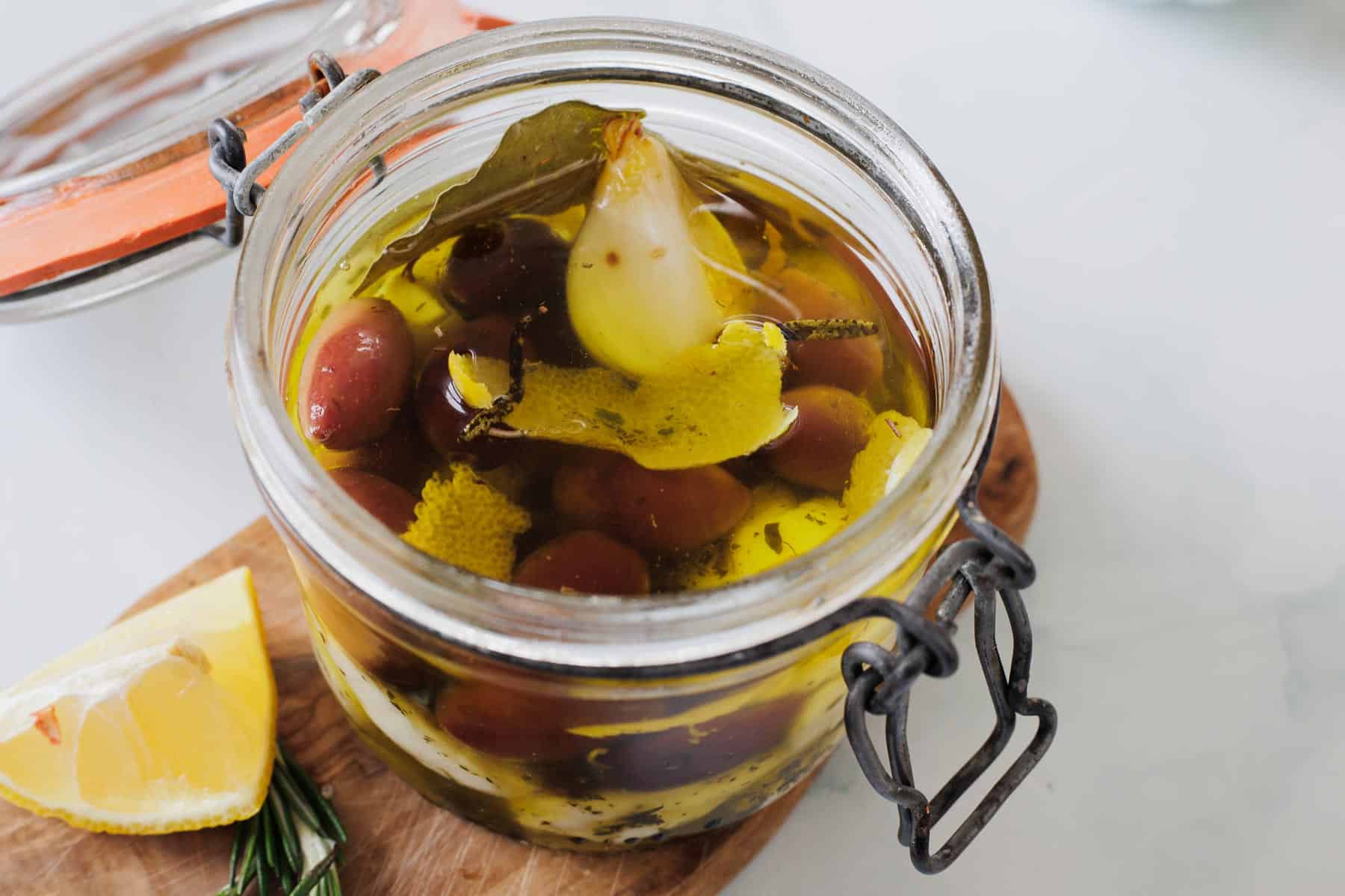 cheese curds in a jar on a wooden cutting board.