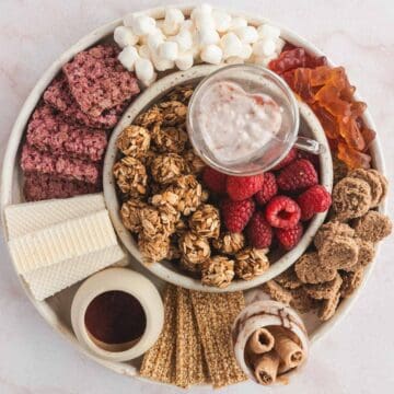 A plate filled with granola, crackers and berries.