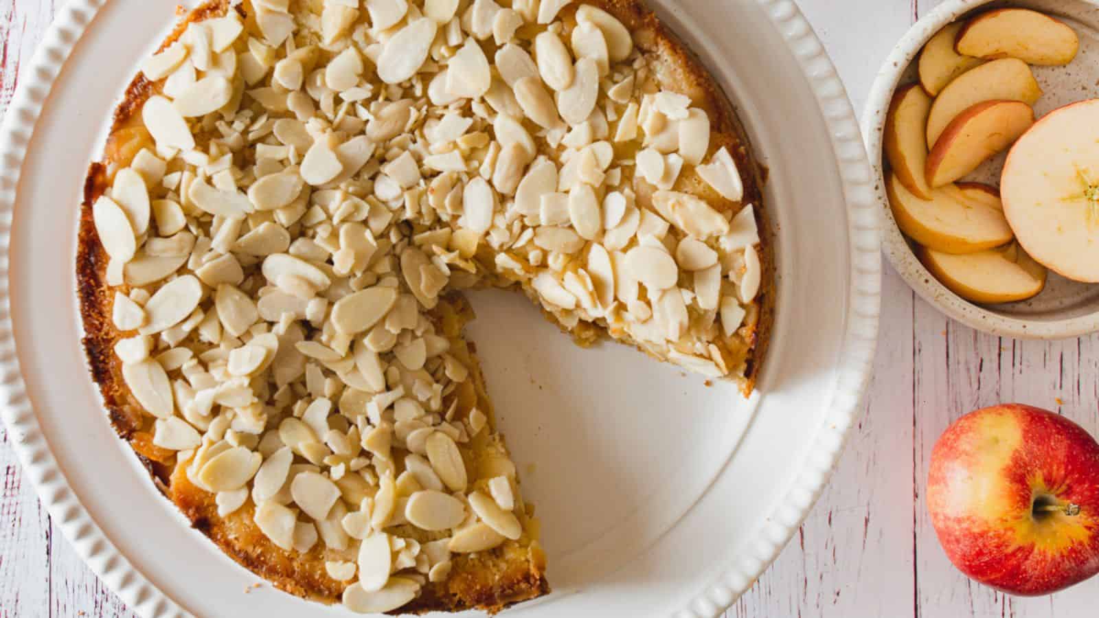 A plate of apple pie with a slice taken out of it.