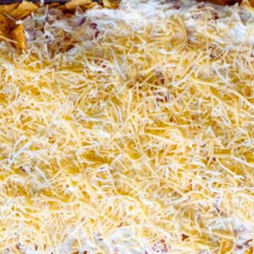 A baking dish filled with a layer of nachos topped with melted cheese, embodying the essence of comfort food.