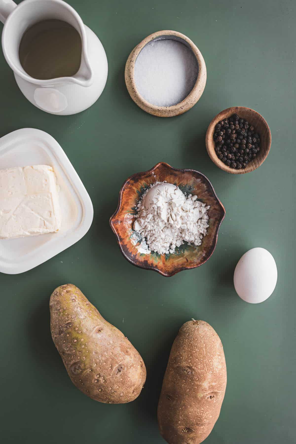 Ingredients for mashed potatoes latkes on a green table.