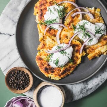 A plate of irish boxty pancakes with onions and sour cream.