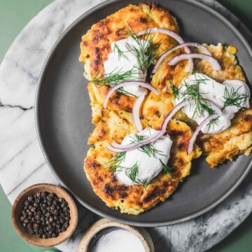 Gluten-free Irish boxty with sour cream and onions on a plate.
