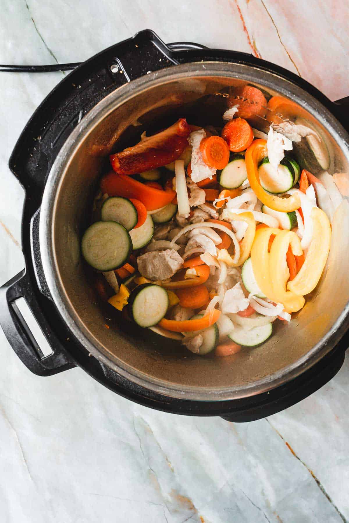 An instant pot filled with vegetables and chicken.