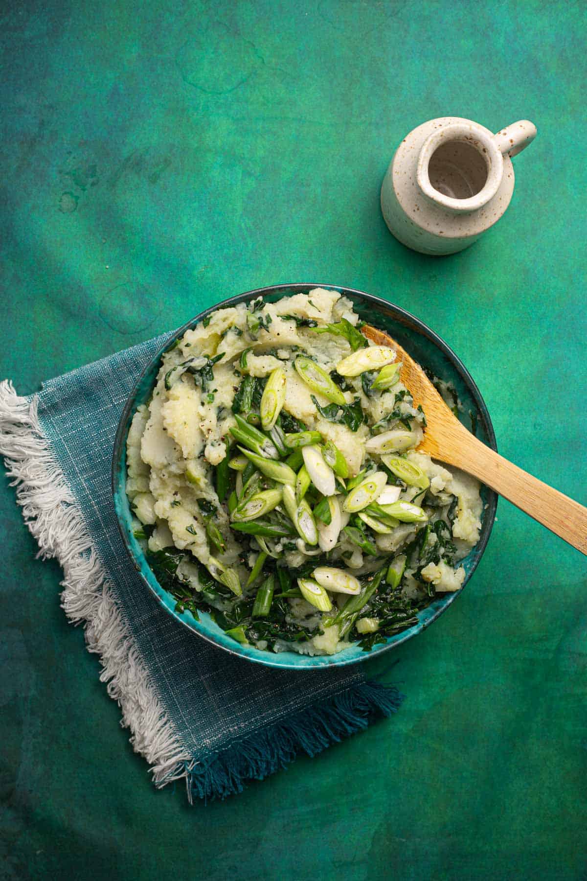 A bowl of Irish colcannon with a wooden spoon.