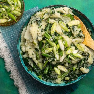 A bowl of Irish colcannon with a wooden spoon.