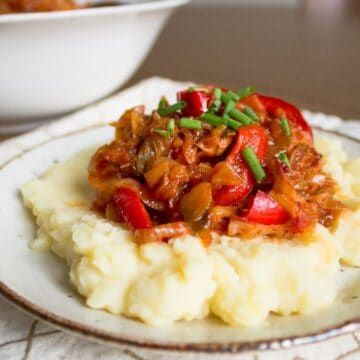 A plate with mashed potatoes and meat on it.