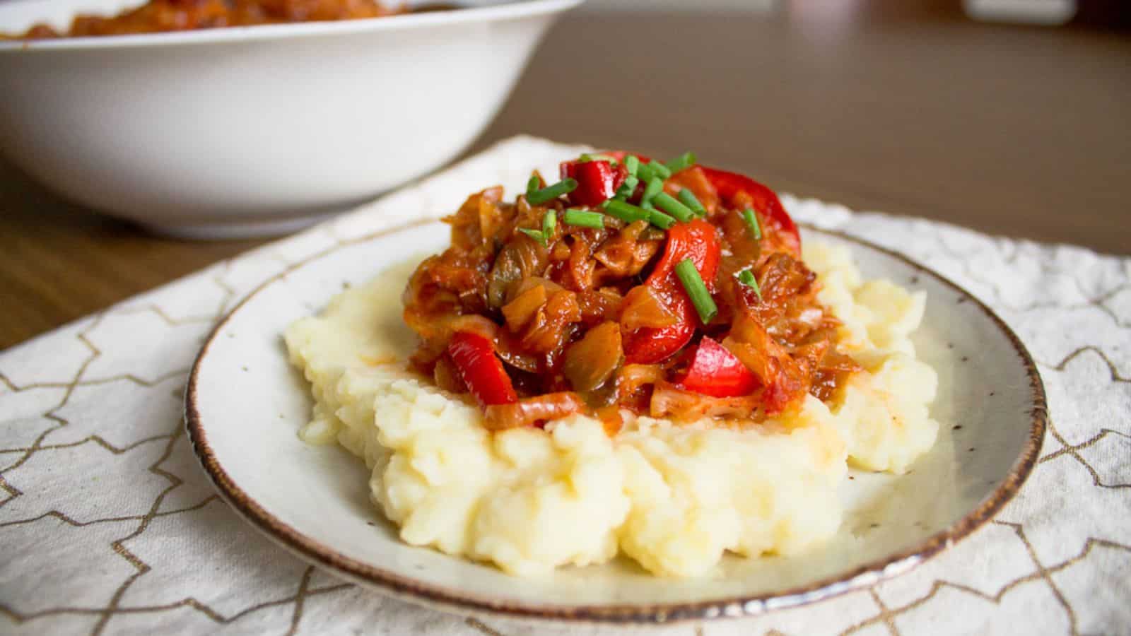 A plate with mashed potatoes and meat on it.