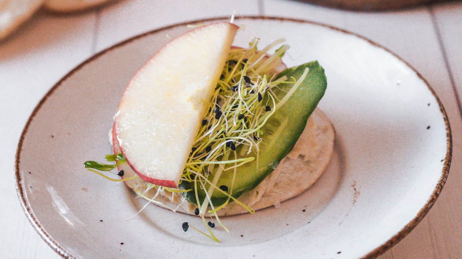 A plate of food with hummus and apples on it.