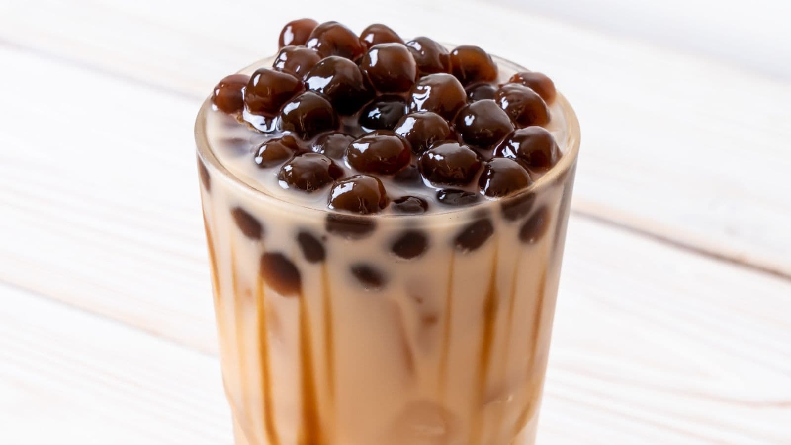 A glass of bubble tea with milk and a layer of tapioca pearls on top is a delightful recipe in the drinks category you should try sooner.
