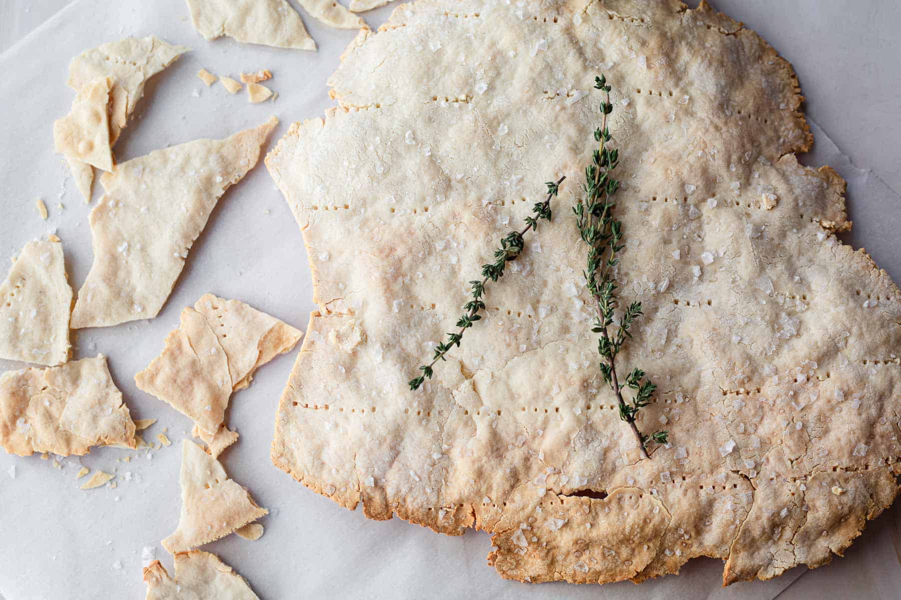 A large piece of gluten free matzo broken into smaller pieces. Topeed with a. thyme sprig.