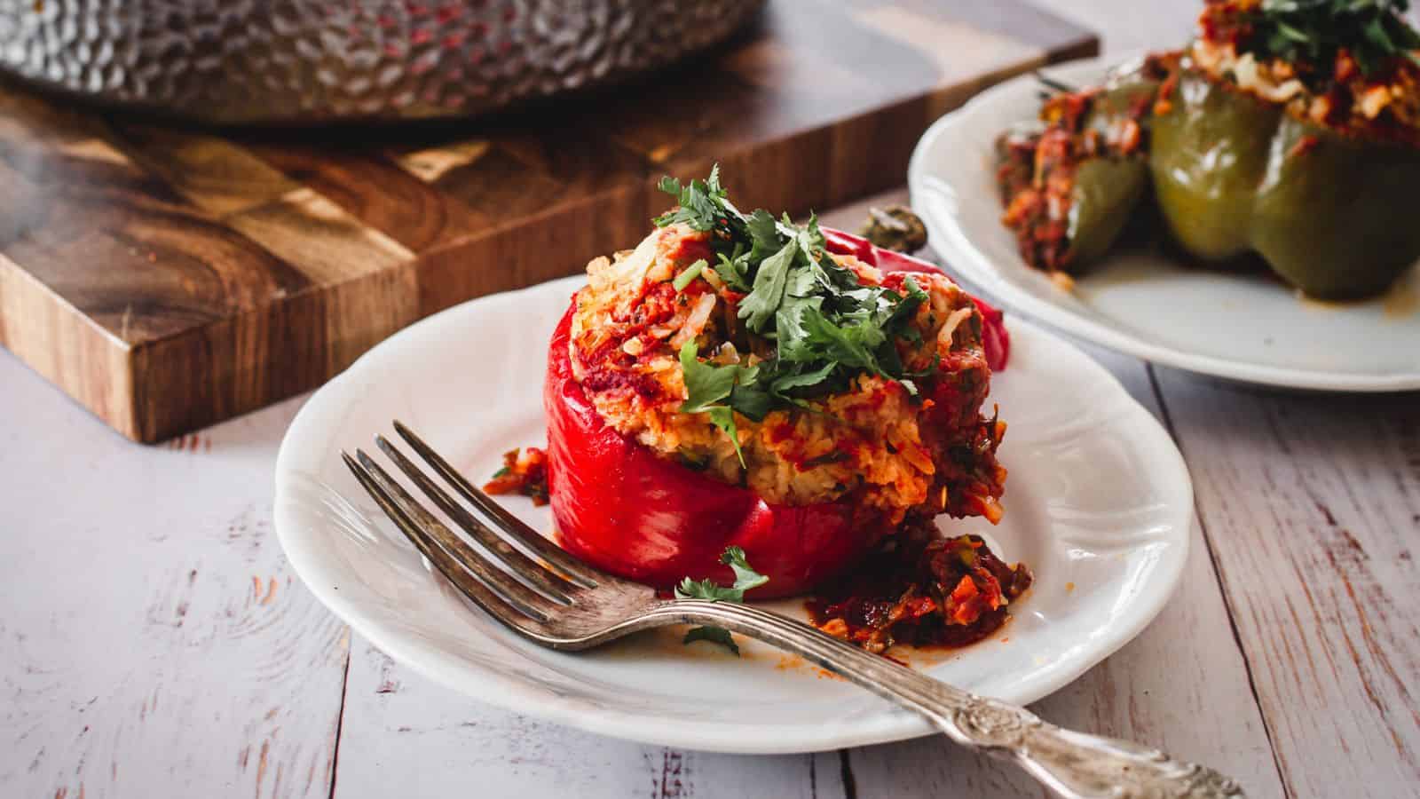 Stuffed red pepper on a plate with a fork.