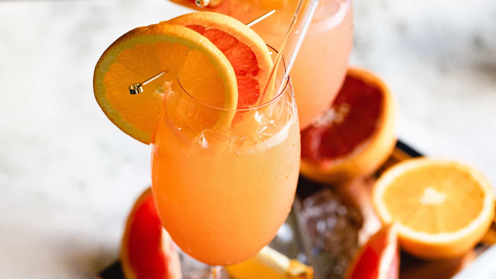 two glasses with citrus garnishes.
