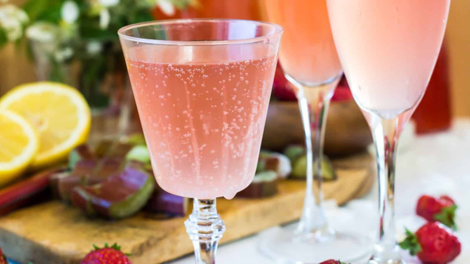 Three cocktail glasses with ingredients in background.