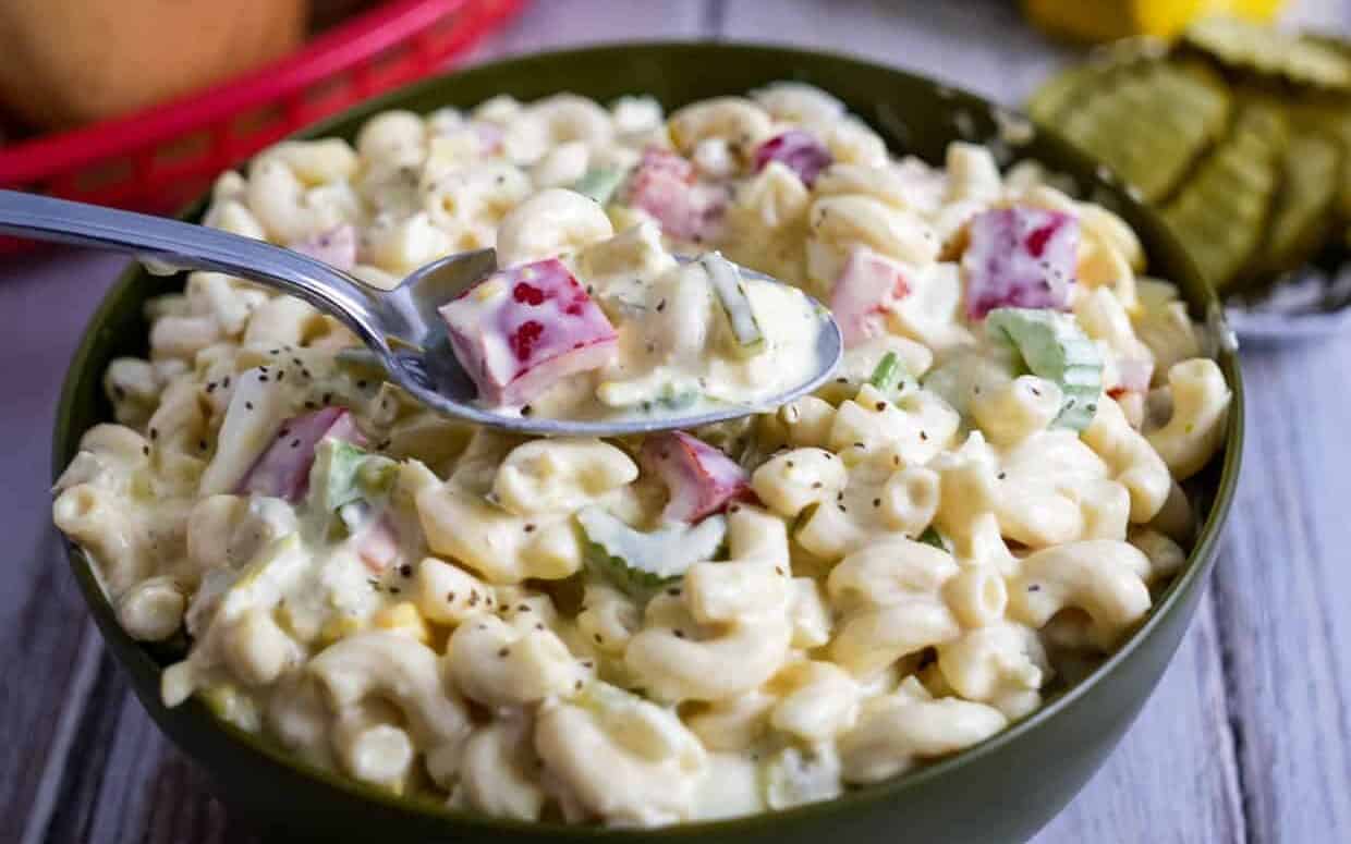 Bowl of Amish macaroni salad with some on a spoon.