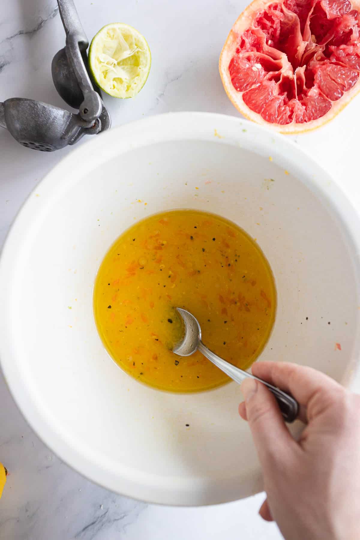 Citrus marinade being mixed in a white bowl.