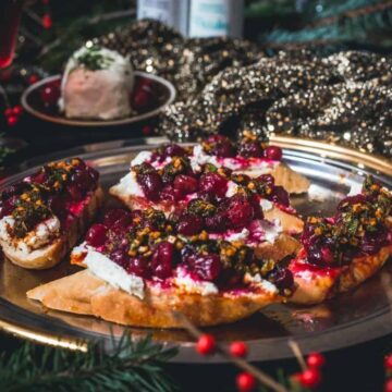 Cranberry and pistachio crostini on a plate.