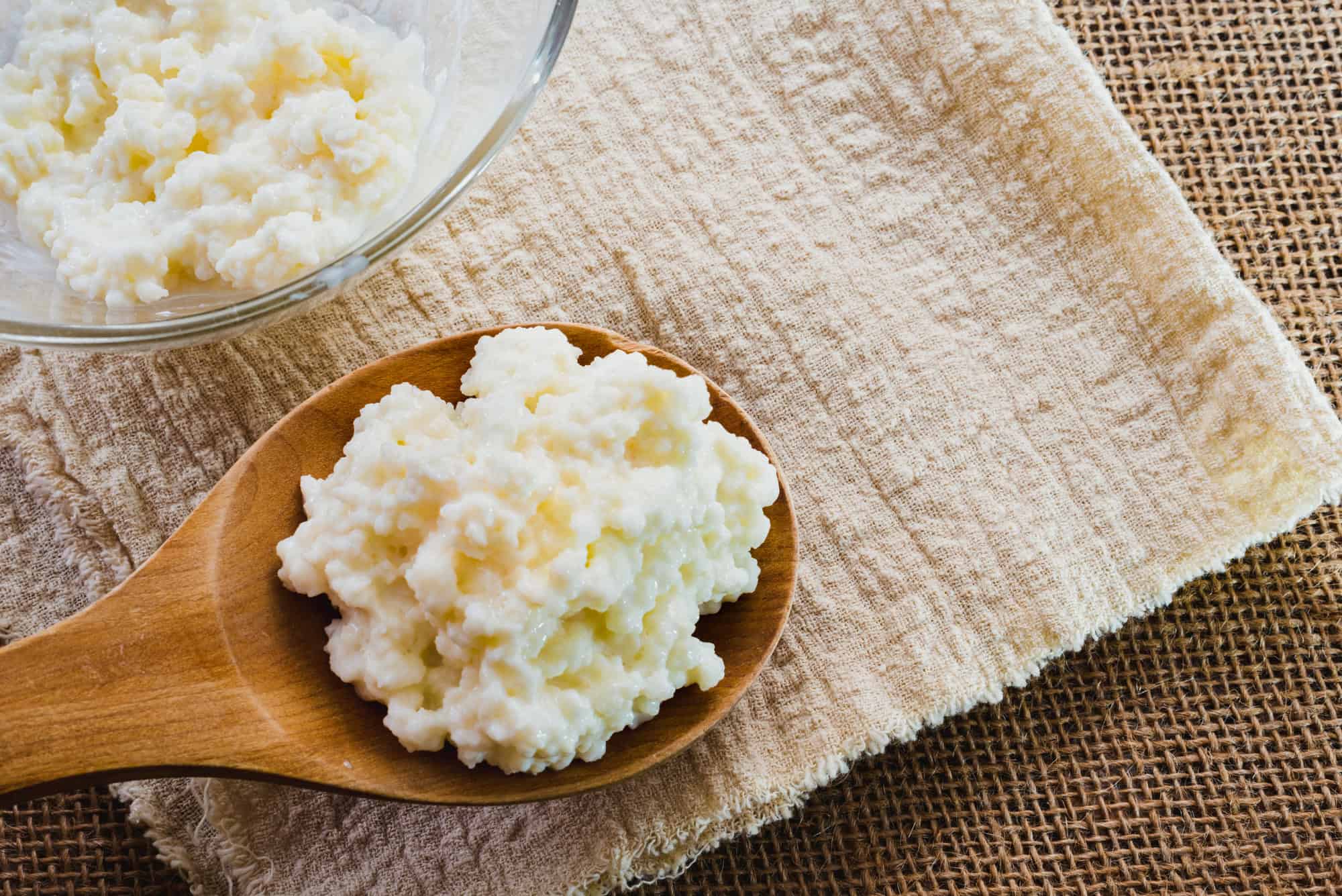 A wooden spoon containing a portion of kefir. 