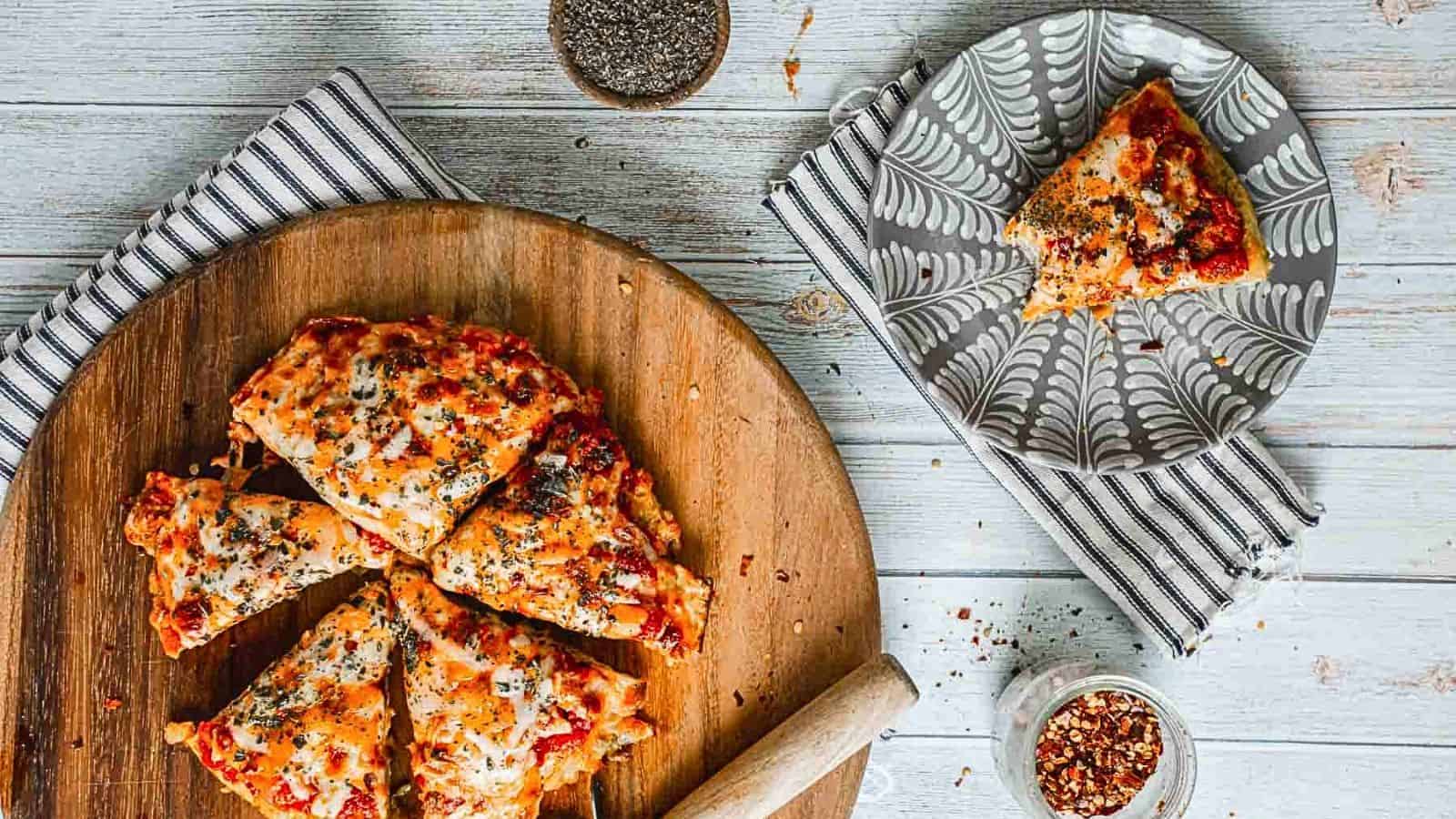 A slice of pizza on a wooden cutting board.