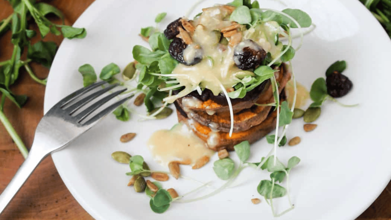 A white plate with sweet potatoes and greens on it.