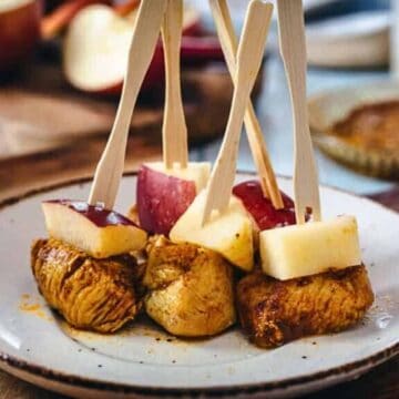 Middle Eastern apple appetizers with cooked chicken and fresh apple chunks skewered on small wooden forks.