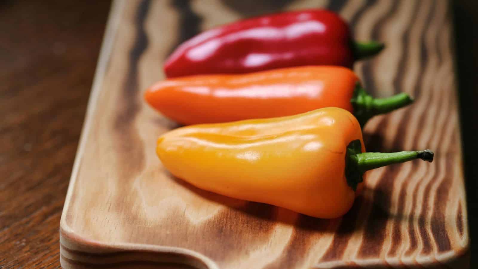 Close-up of three bell peppers placed on a chopping board