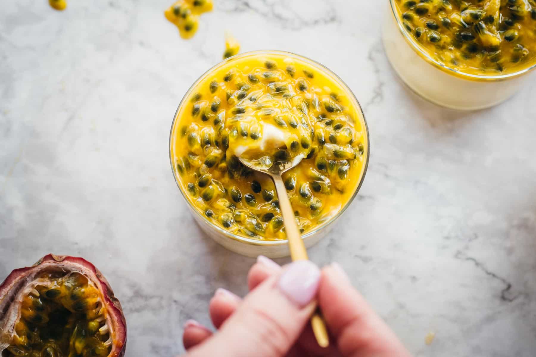 scooping out passion fruit mousse with a spoon.