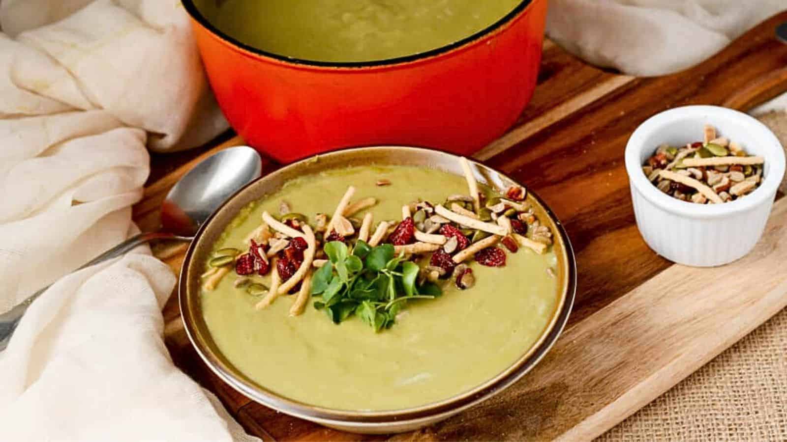 A bowl of soup on a wooden cutting board.