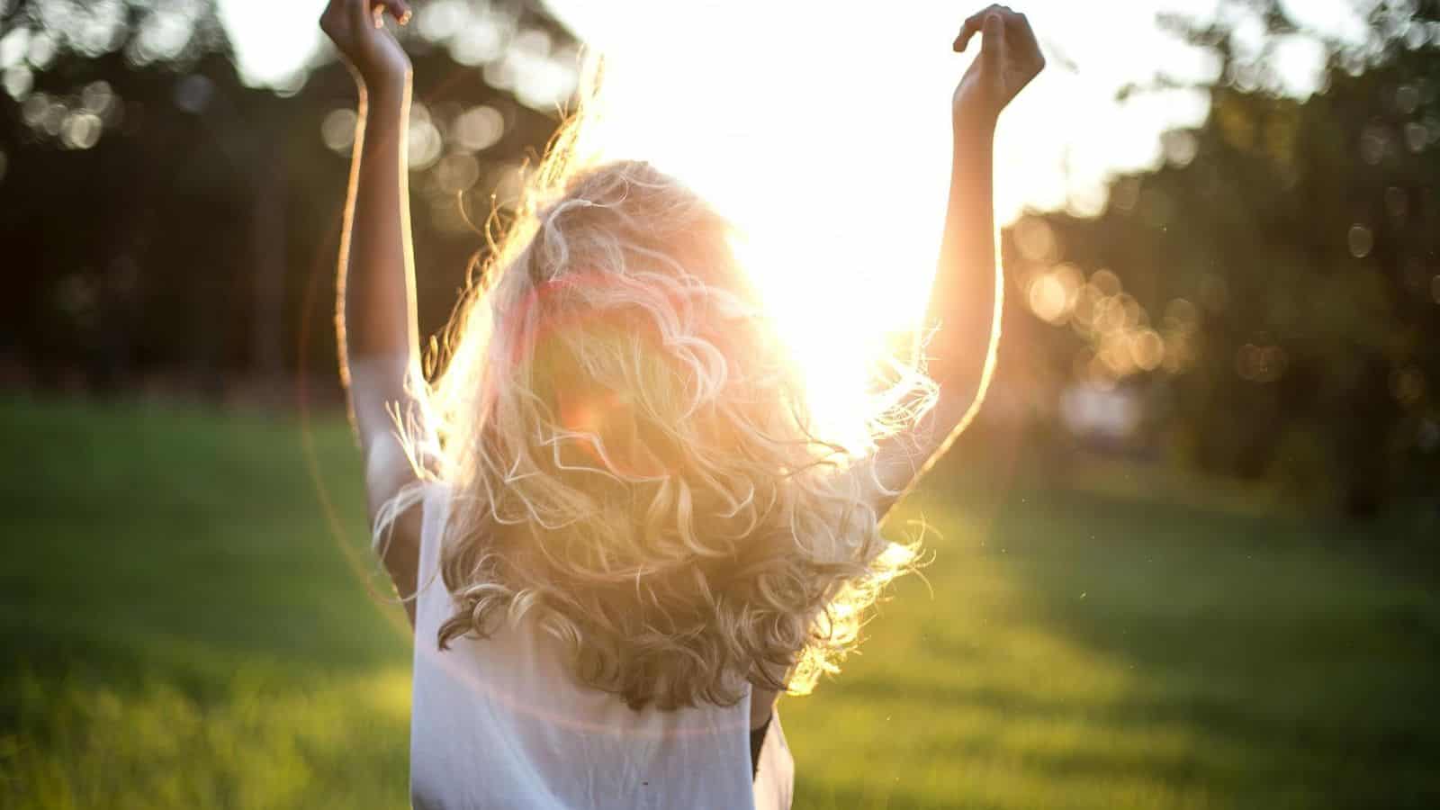 Woman with blonde hair pictured against the sun