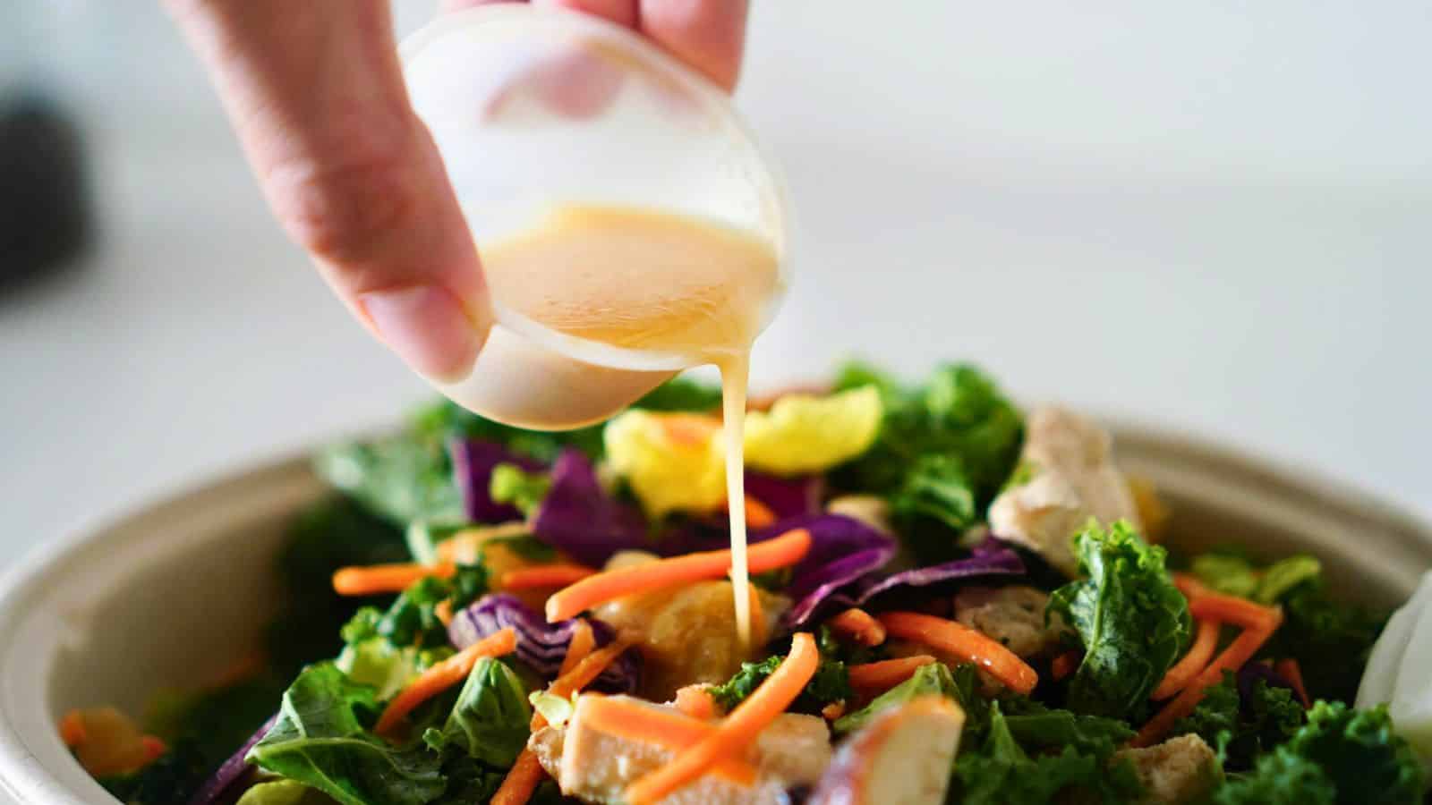 Dressing being poured on salad