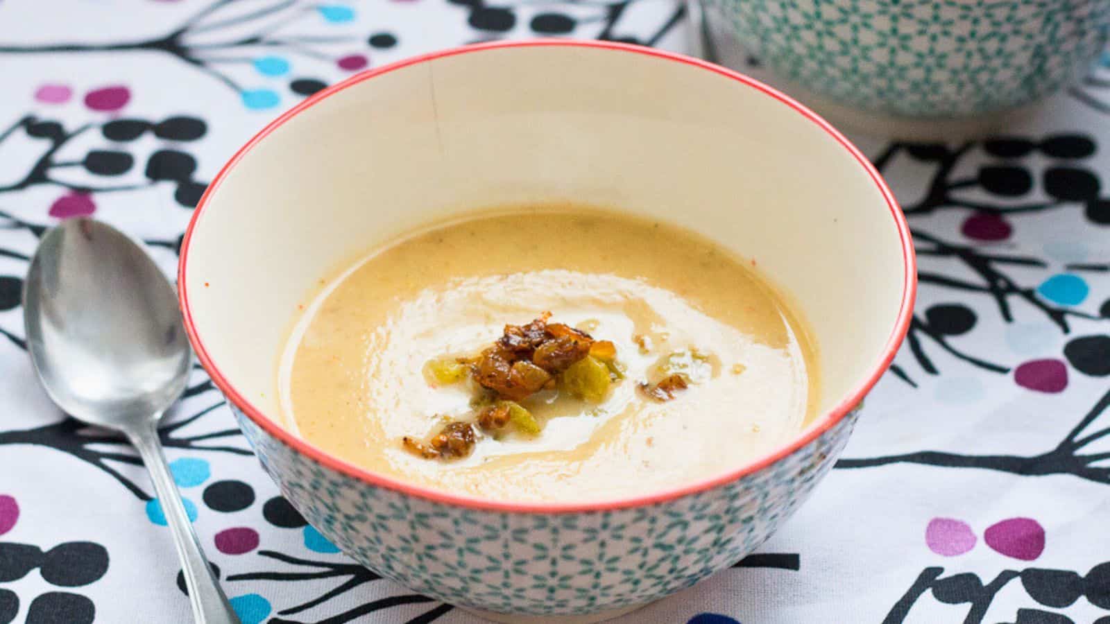 A bowl of soup is sitting on a wooden tray.