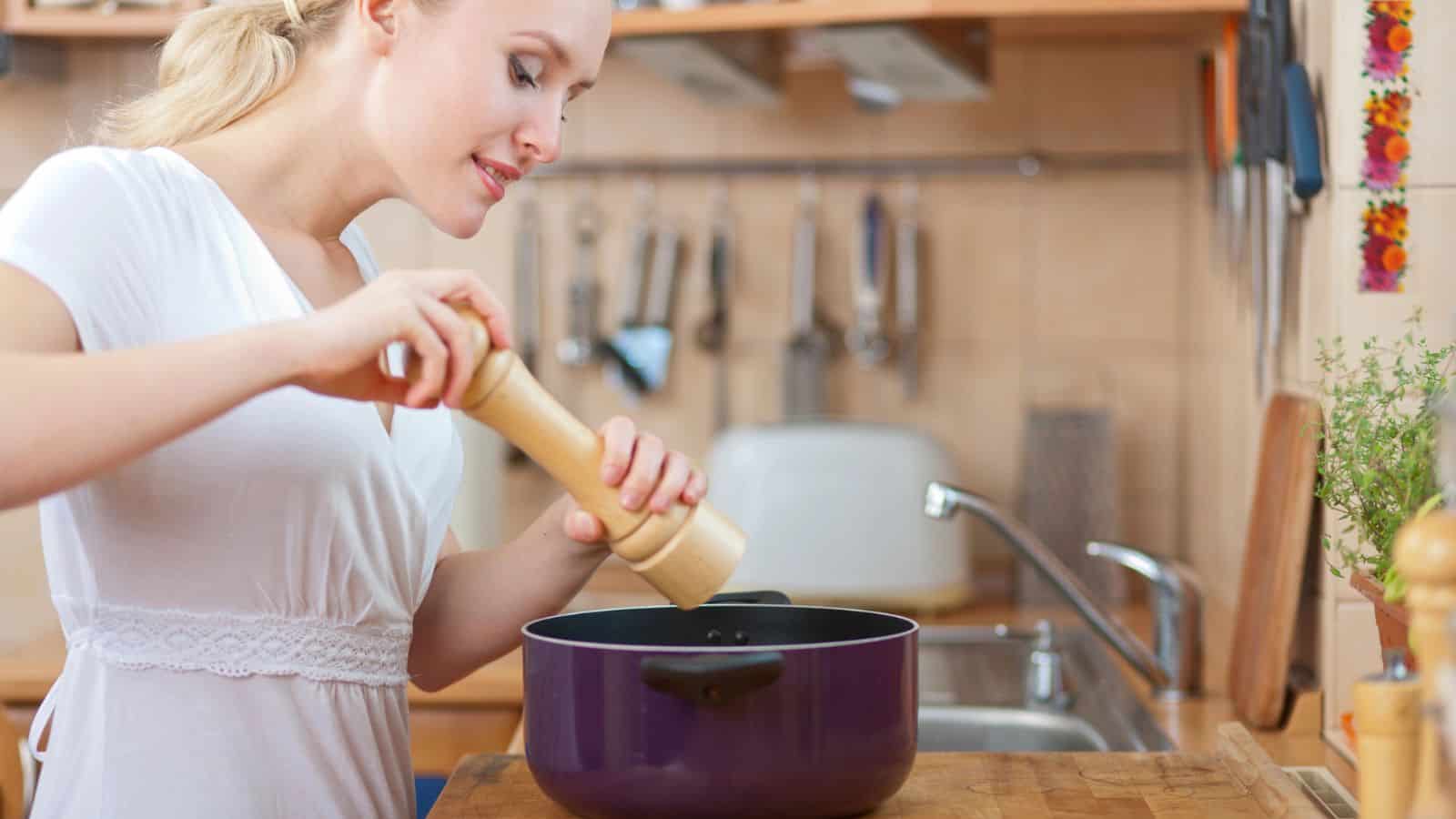 Woman seasoning a brazier pot with salt