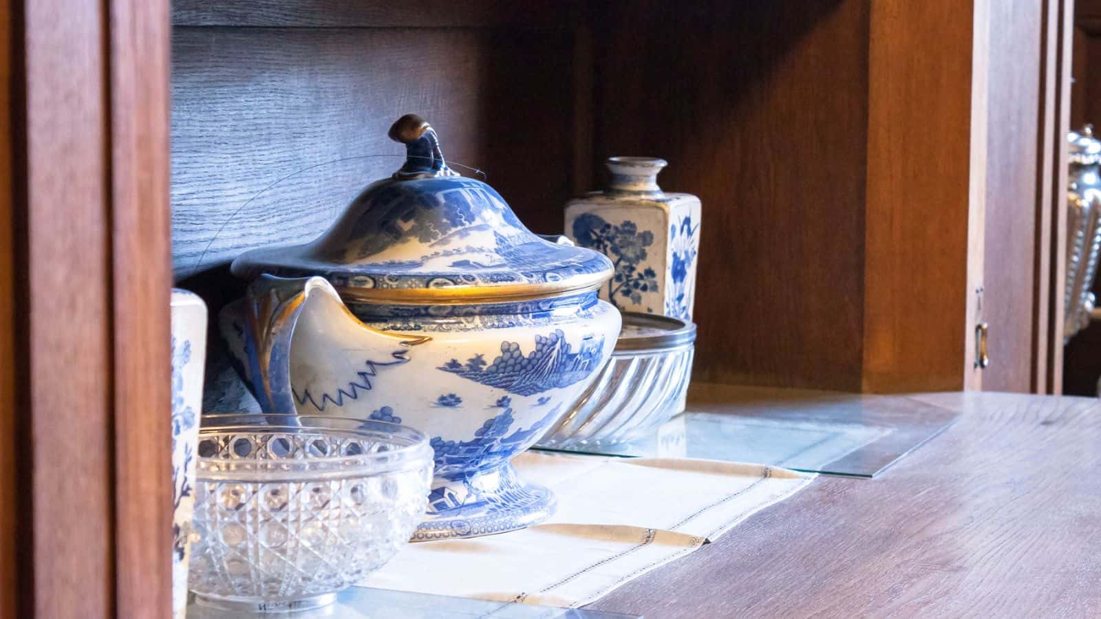 Vintage wares placed on top of lining in a cabinet