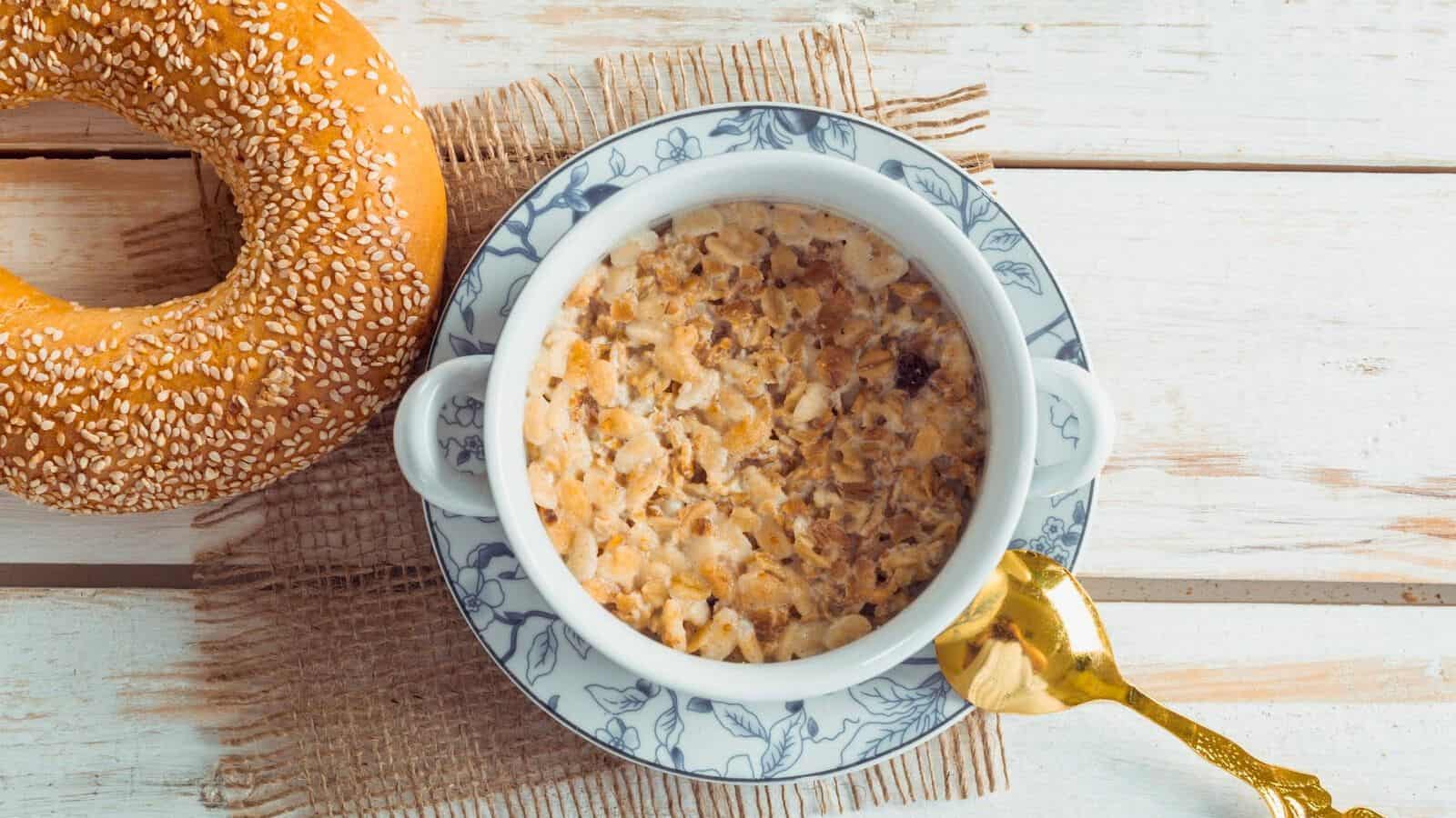 A bowl of breakfast cereal with milk and a donut in the background