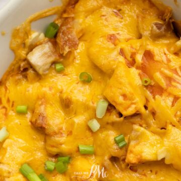 A close-up photo of a classic casserole dish filled with baked cheesy potatoes, topped with melted cheese and chopped green onions. The dish appears golden brown with crispy edges, perfect for Monday dinners or reminiscent of Grandma's recipes.
