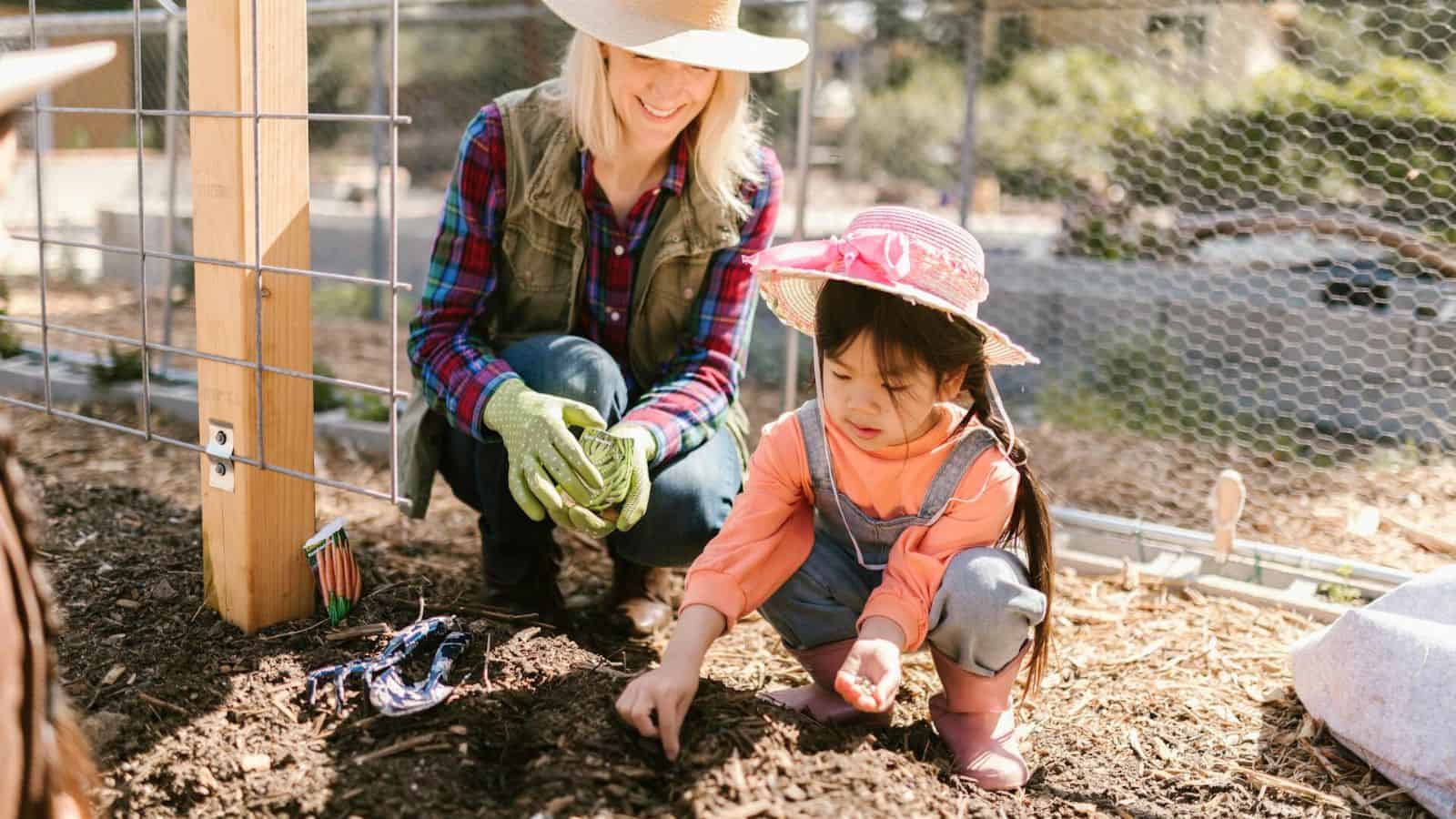 An adult woman watching a kid doing things on the soil