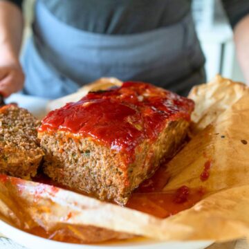Person holding out a tray of meatloaf