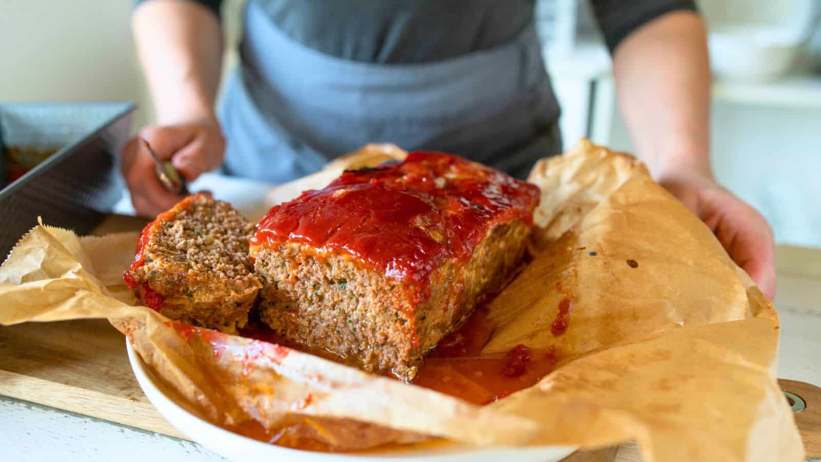 Person holding out a tray of meatloaf